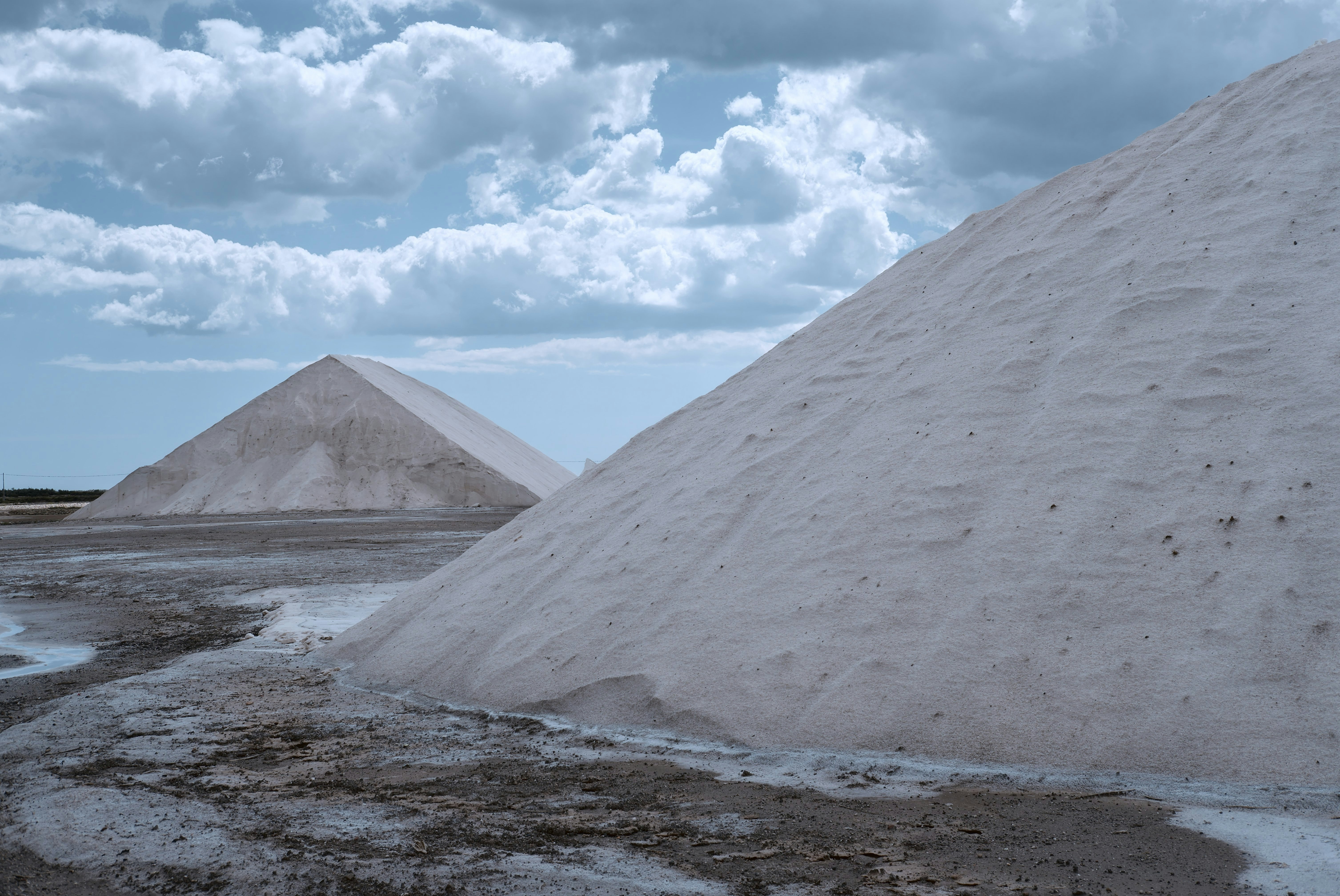 beige hills under white cloudy sky at daytime